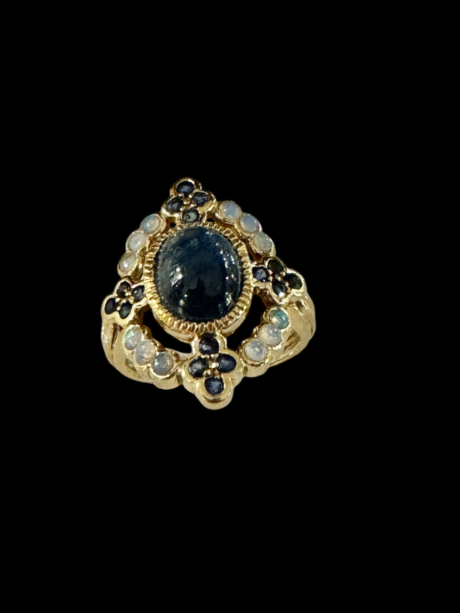 Bague ornée d'un saphir étoilé et d'opales